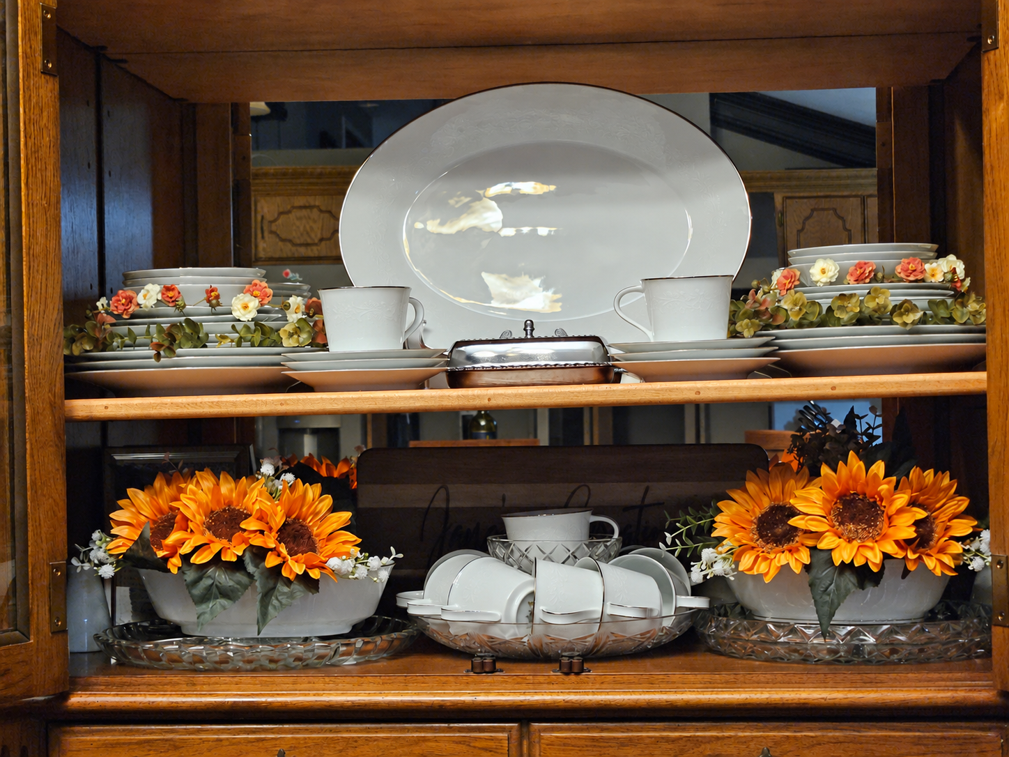 A close-up of floral china, a serving plate and flowers displayed in Jana’s china hutch